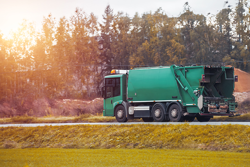 recycling truck rides on road suburbs